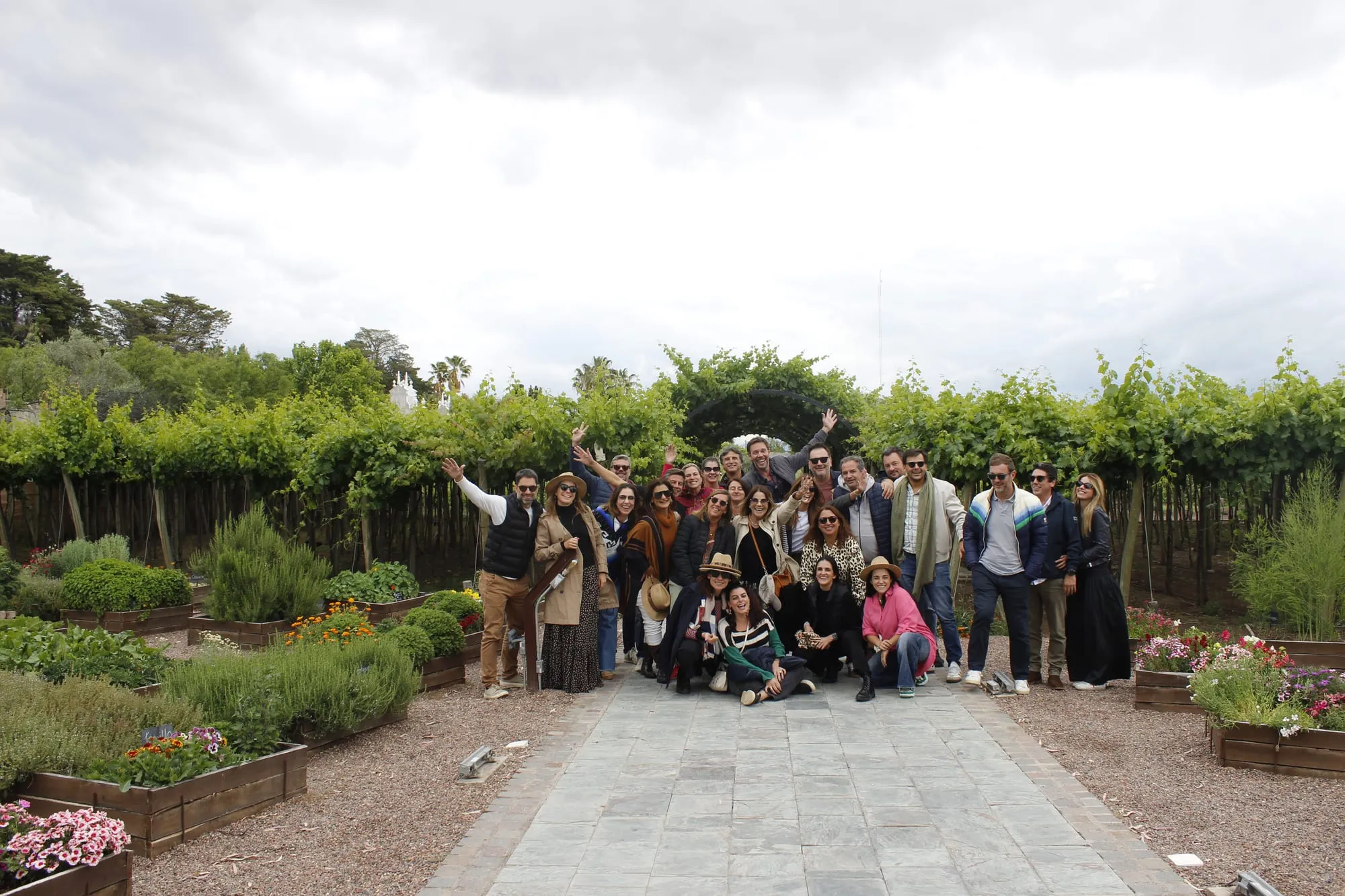 Grupo de viajeros celebrando en el jardín de una bodega