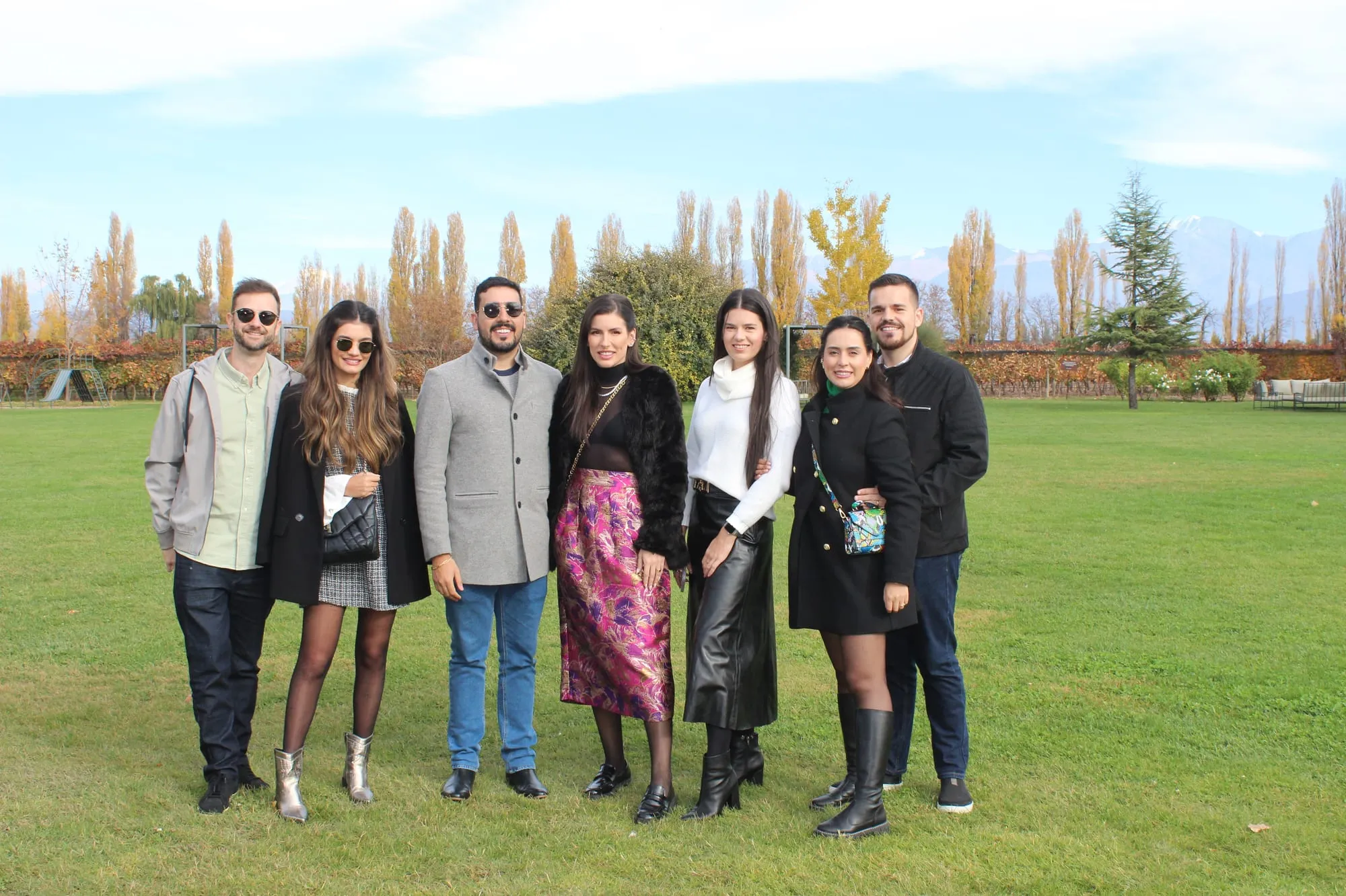 Grupo de amigos entre los álamos de una bodega en otoño