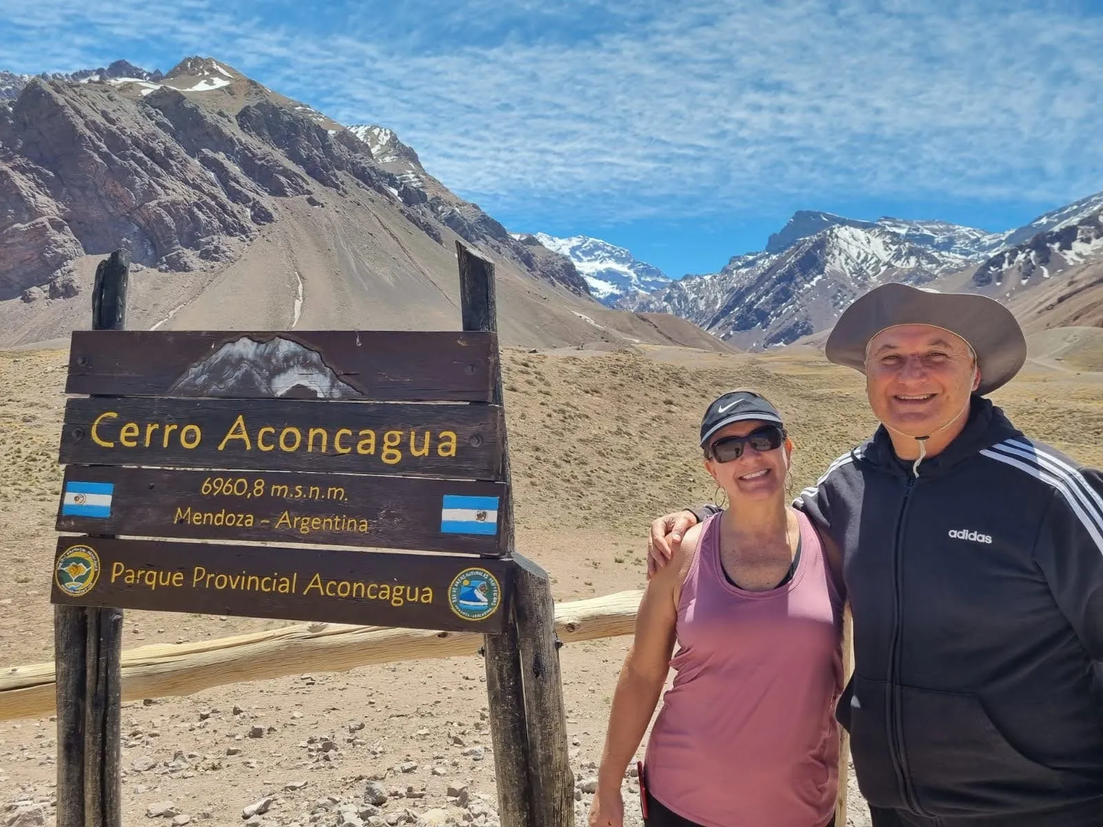 Pareja de viajeros en el cartel del Cerro Aconcagua